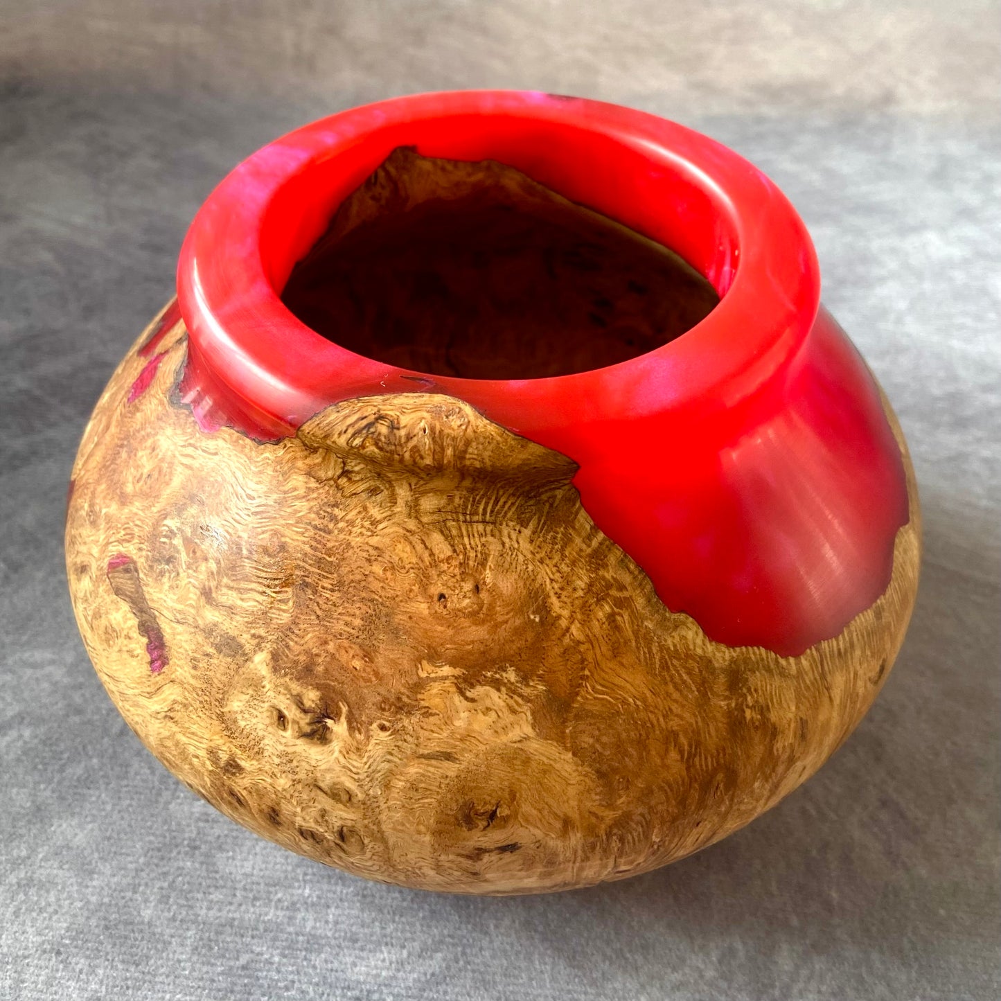 Vase with red top and textured gold body on a gray background