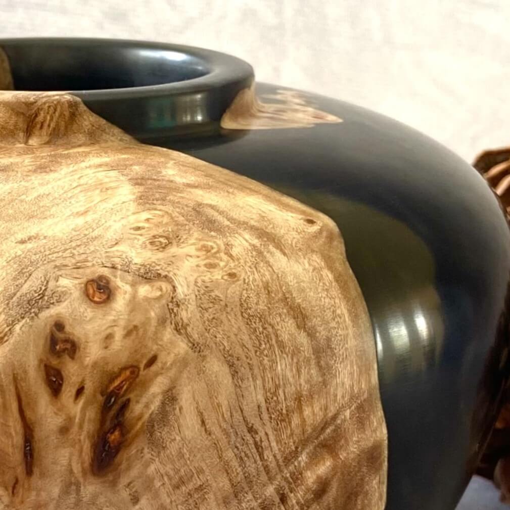 Close up texture of intricate Mappa Burr grain meeting glossy black resin