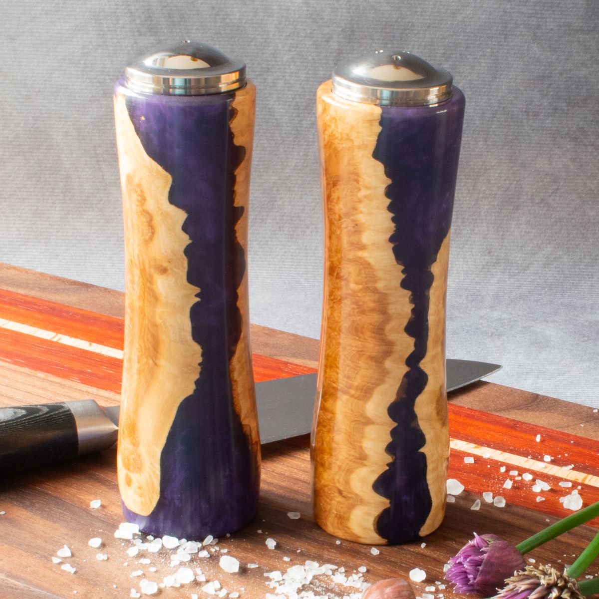 Salt & pepper shaker set in mallee burr & purple resin front view on charcuterie board