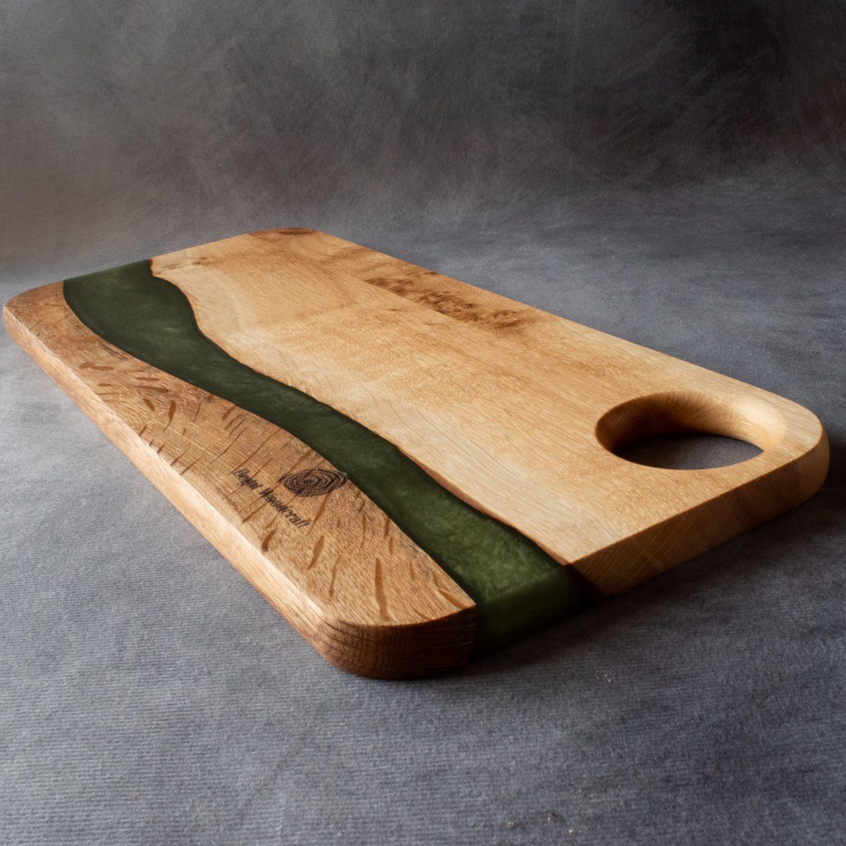 Medium charcuterie board in english oak with green resin viewed from the handle end