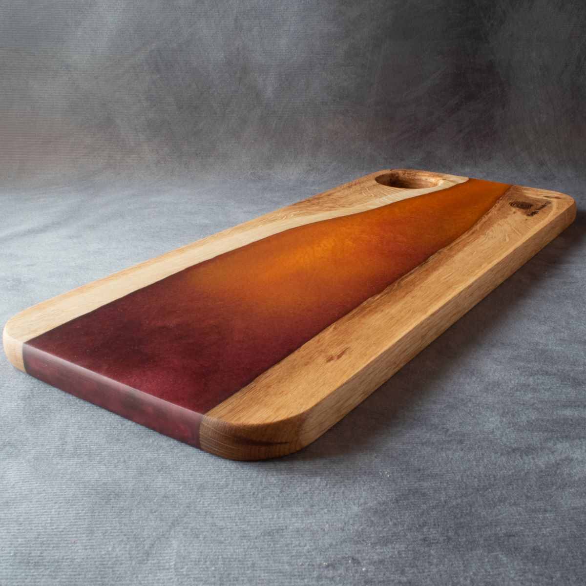 Medium charcuterie board in english oak with orange and red resin viewed from the bottom edge