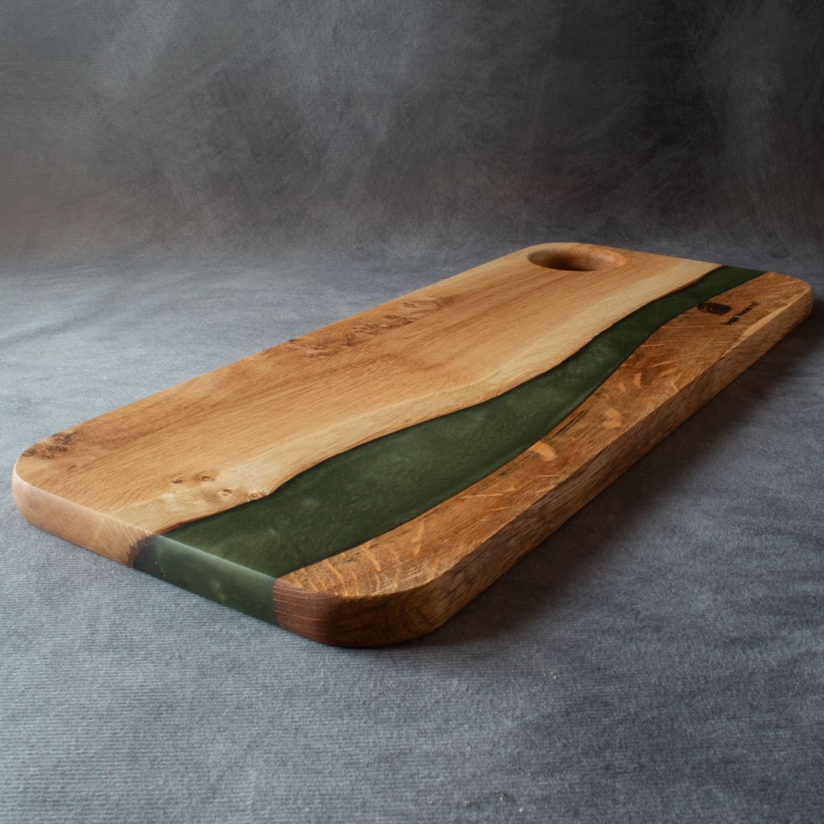 Medium charcuterie board in english oak with green resin viewed from the bottom edge