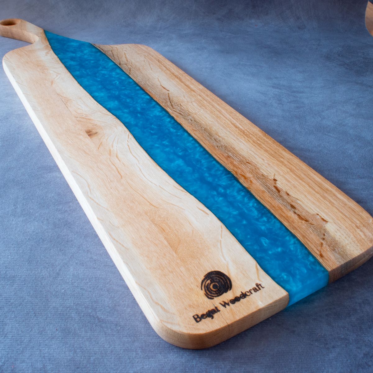 Charcuterie board in English oak and turquoise resin viewed from bottom edge