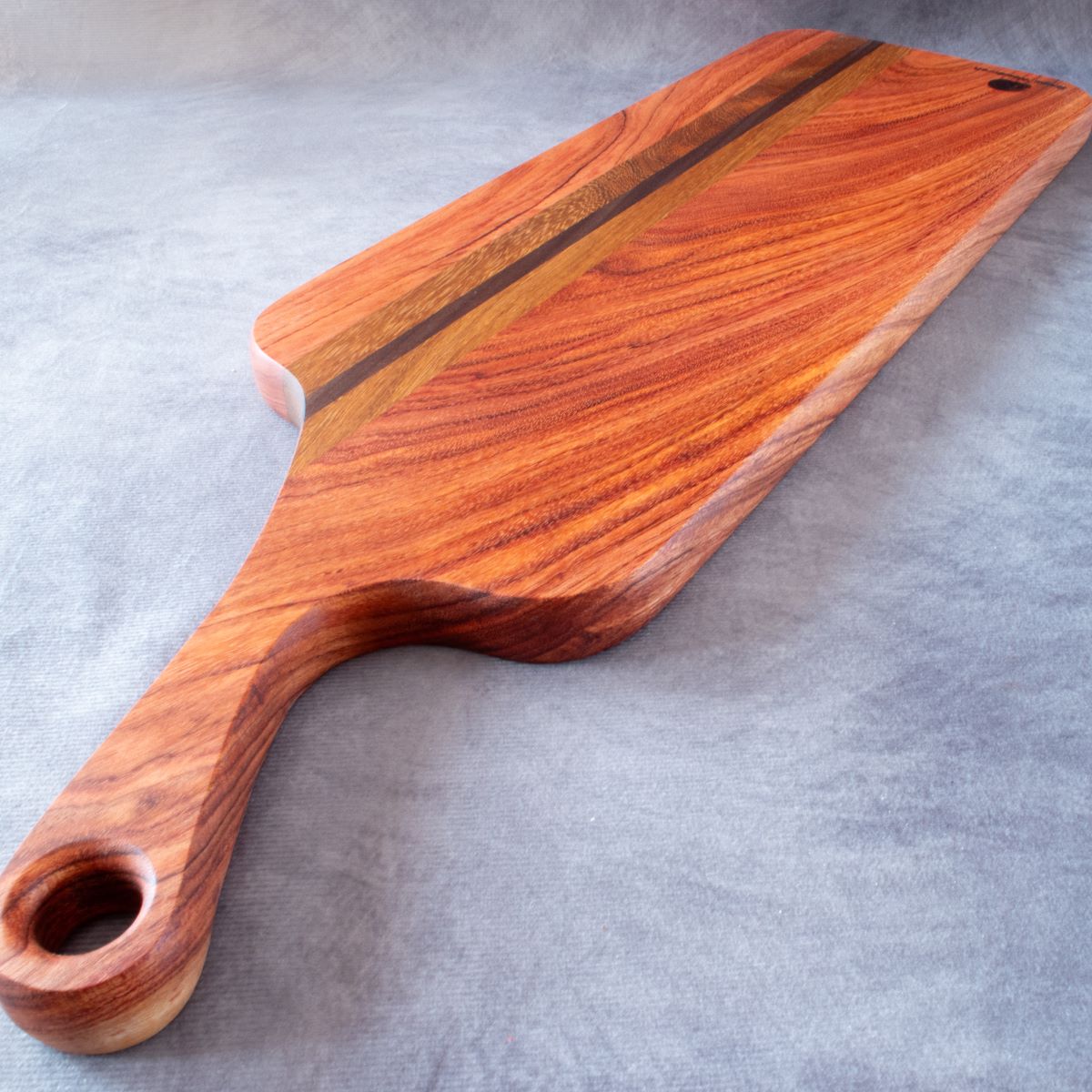 Charcuterie board in African Rosewood & Kiaat viewed from handle end