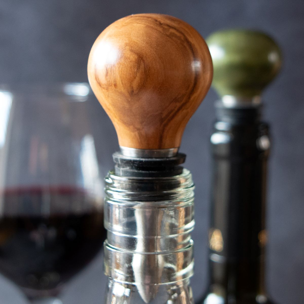 Wine stopper in olive wood shown in bottle top