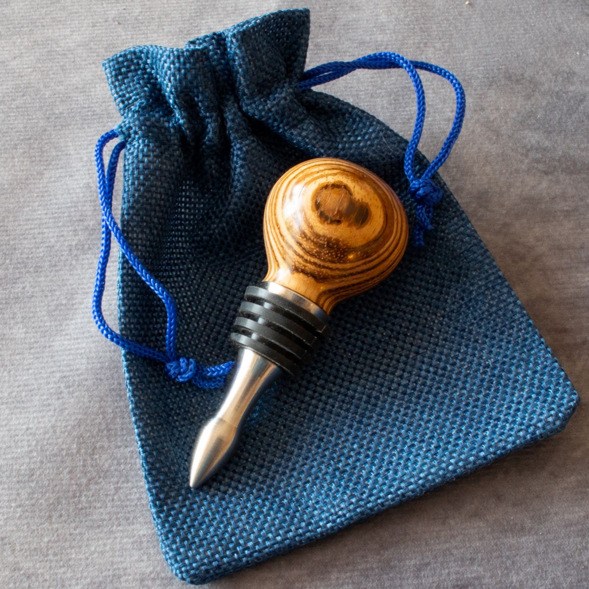 Wine stopper in zebrano displayed with cloth bag