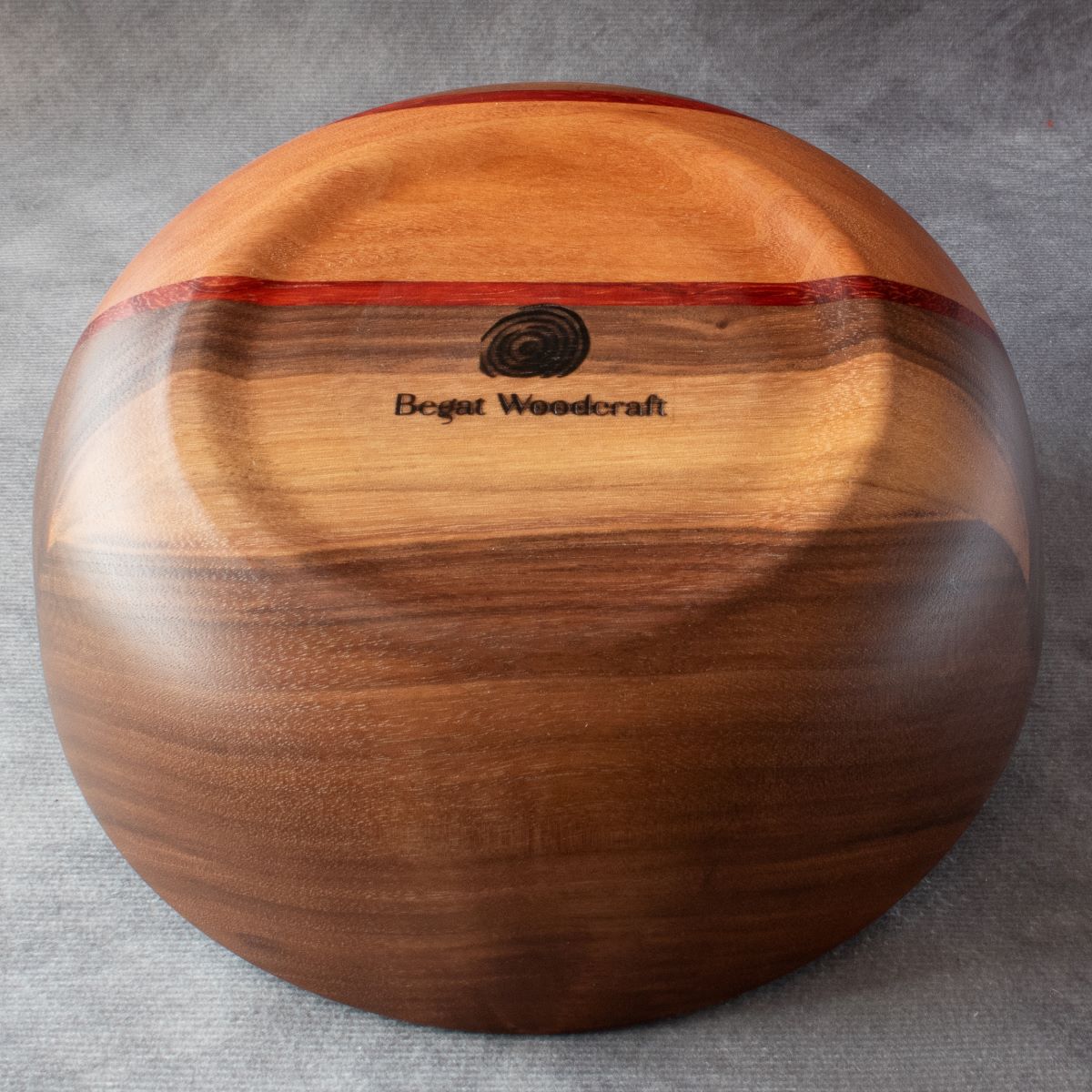 Wooden salad bowl in walnut padauk and cherry bottom view showing branding