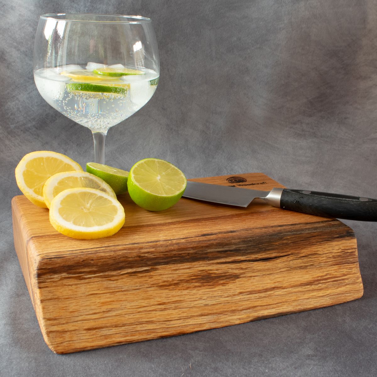 English oak cocktail board shown with lemons and limes