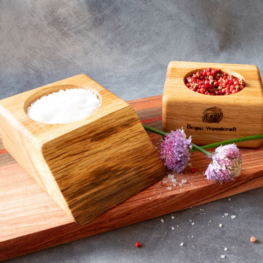 2 natural edge oak pinch pots on a board with chive flowers