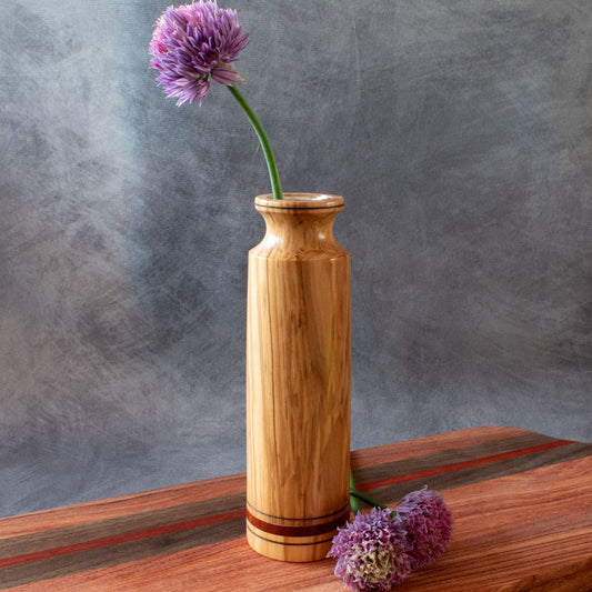 Tall olive bud vase shown with chive flower