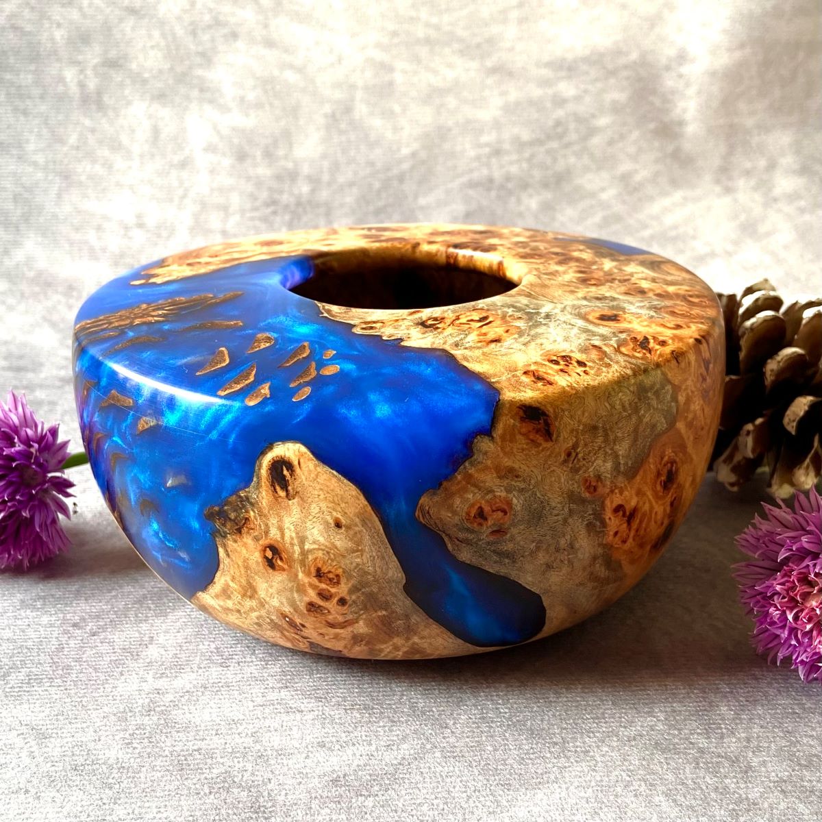 Cobalt blue and mappa burr hollow form pictured with chive flowers