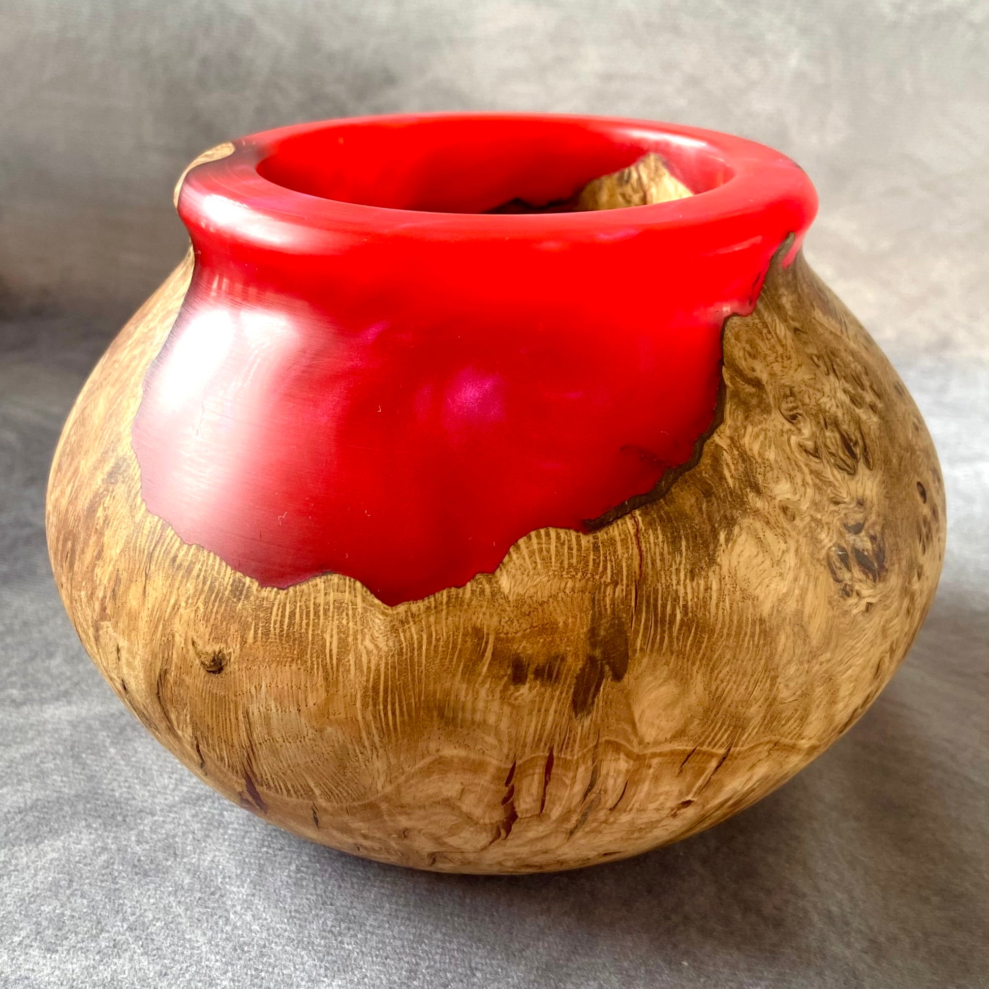 Vessel with wooden texture and red interior on a gray background