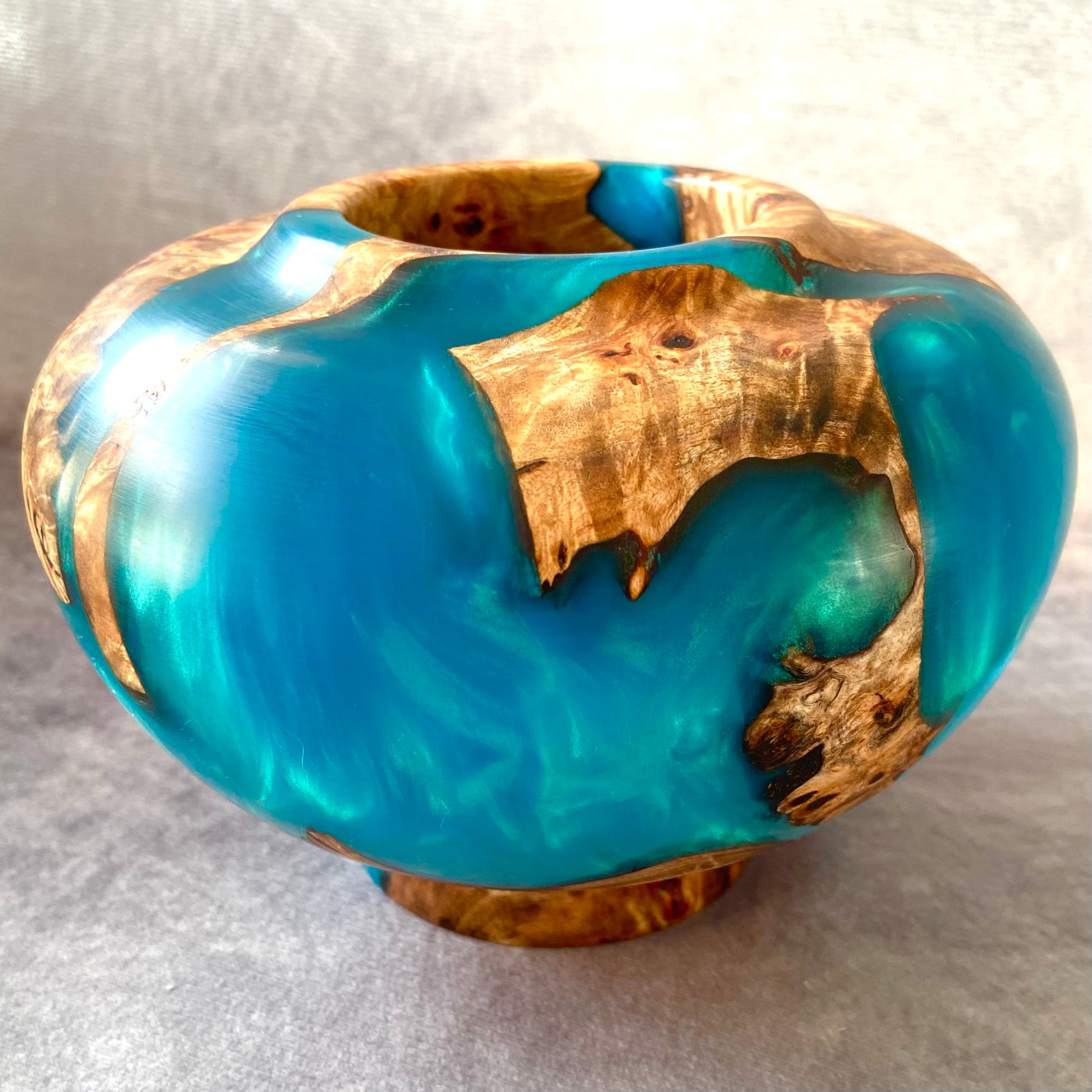 Vase with blue resin and wooden inlay on a light gray background