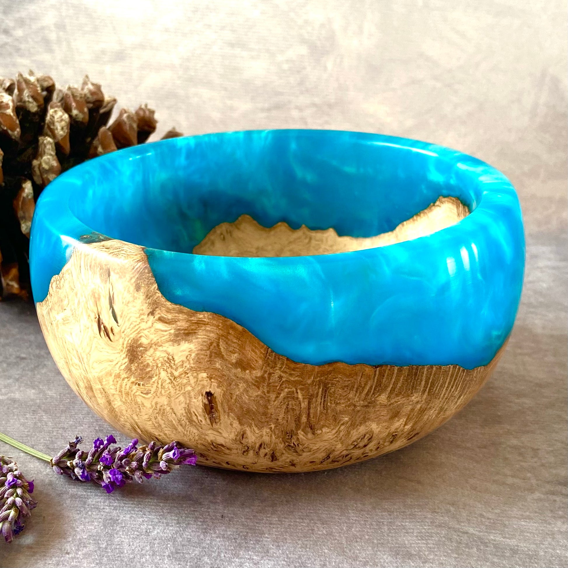 Oak bowl with blue top and natural bottom on a neutral background