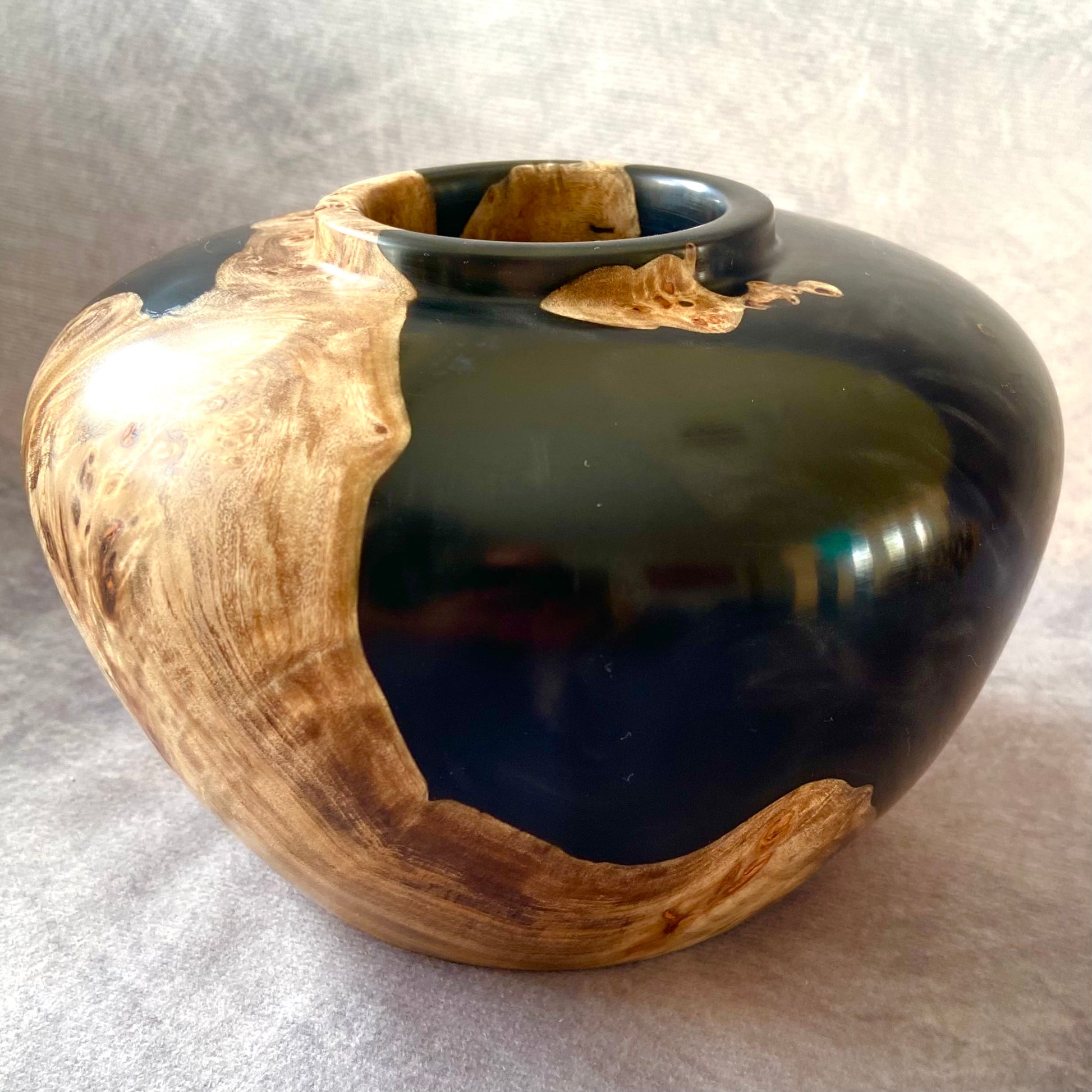 Black and wood-textured vase on a light gray background