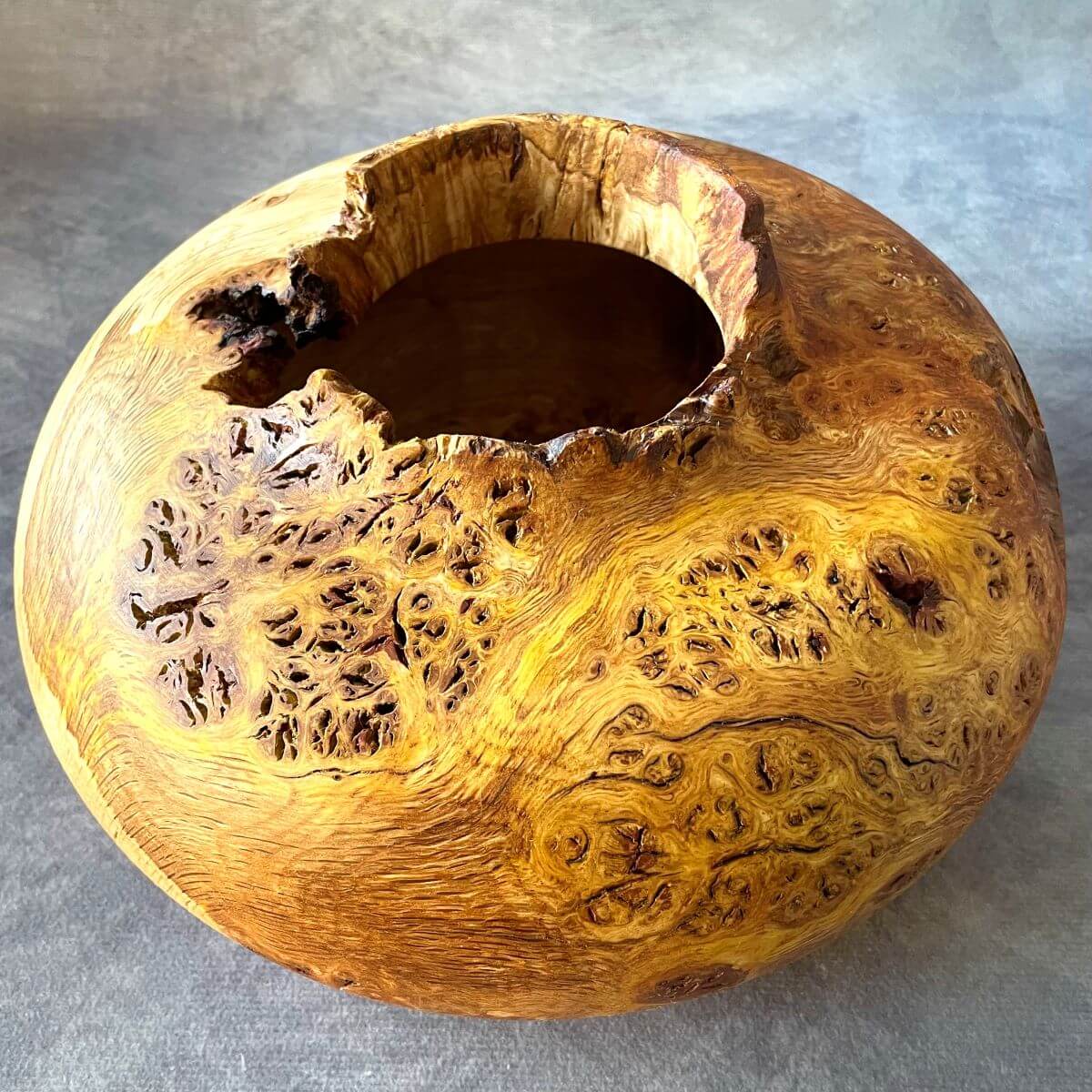 Natural pip grain and textured opening on an English oak burr hollow form.