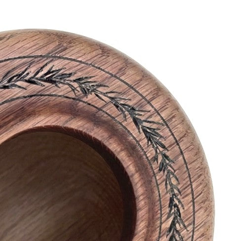Close up detail of laser-engraved leaf motif and natural grain on English Oak Hollow Form