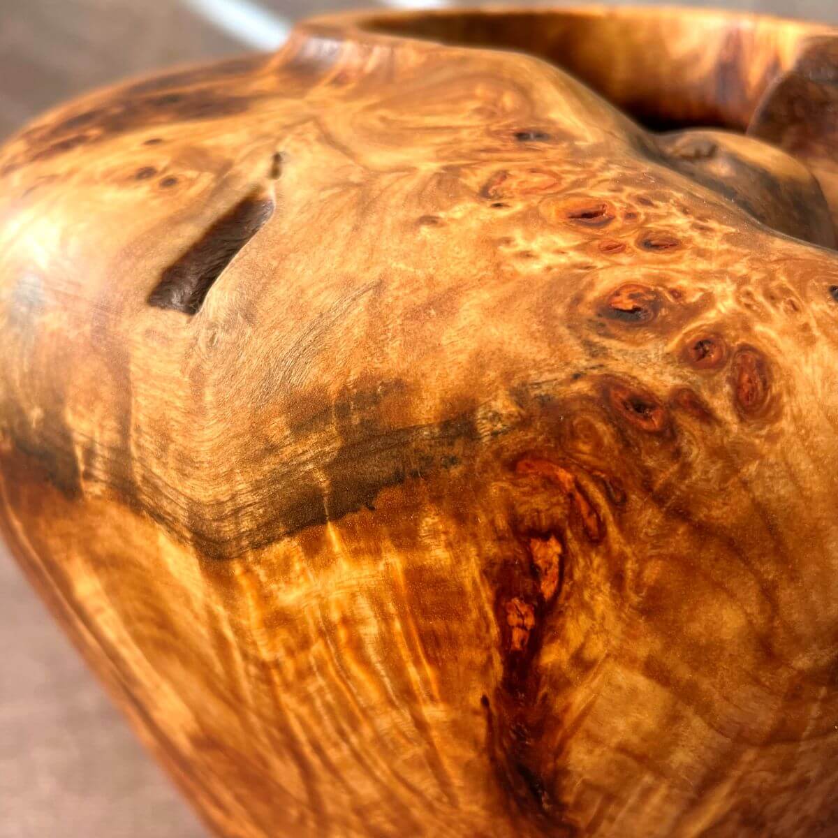 Close up macro shot showing the incredible clustered grain and natural voids of this Mappa burr luxury wood sculpture.