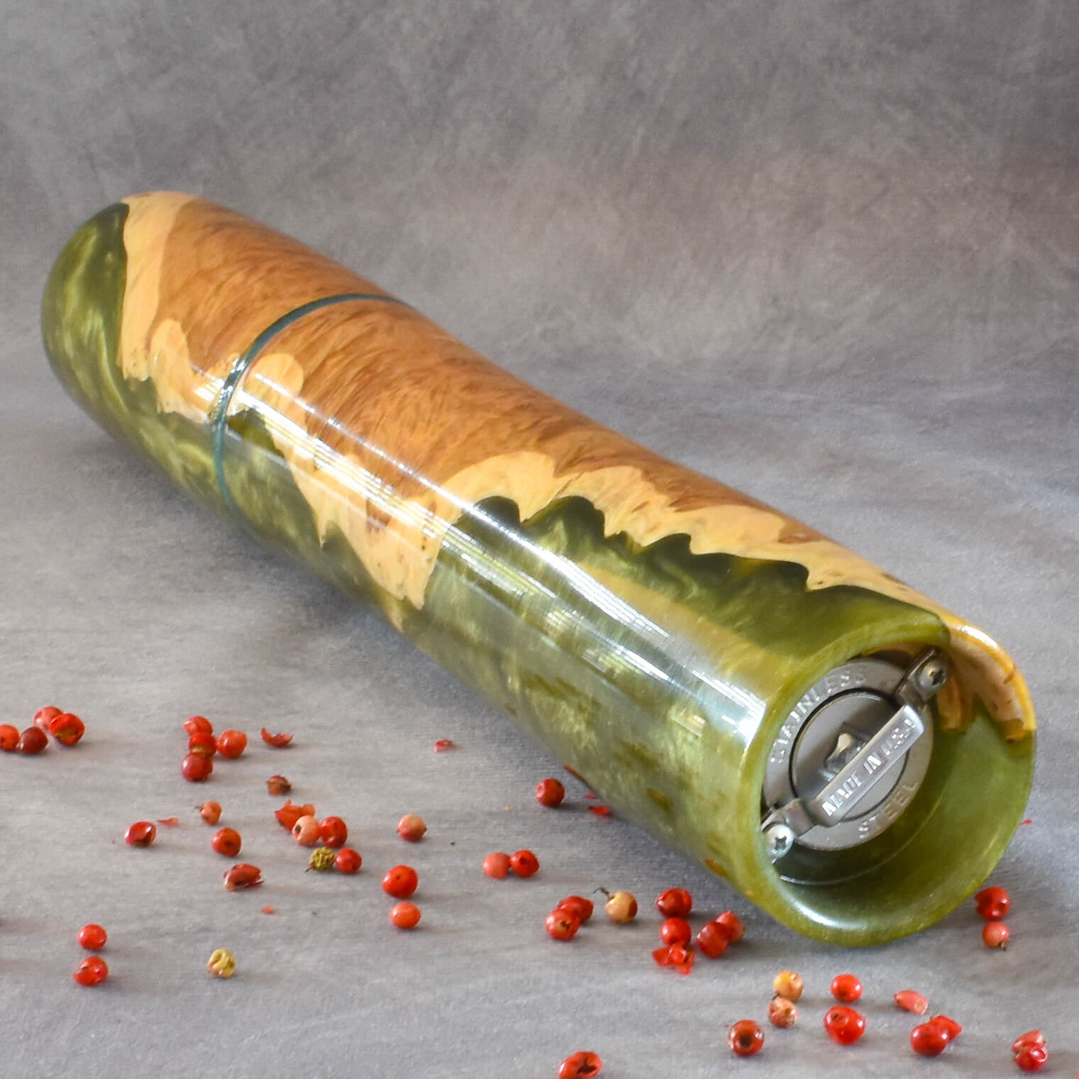 Close up detail of natural grain and high-gloss finish on Mallee Burr and green resin pepper mill showing grinding mechanism
