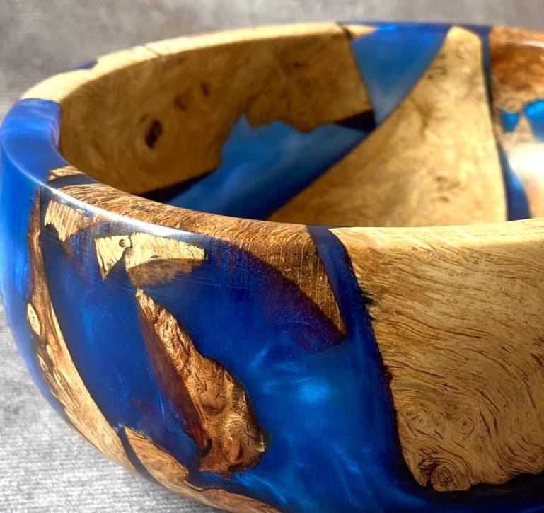 Close up detail of Mappa Burr pieces embedded in cobalt blue resin