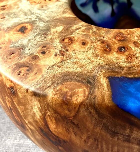 Close up texture of Mappa Burr grain meeting glassy cobalt blue resin