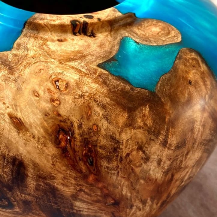 Close up texture of intricate Mappa Burr grain meeting shimmering turquoise resin