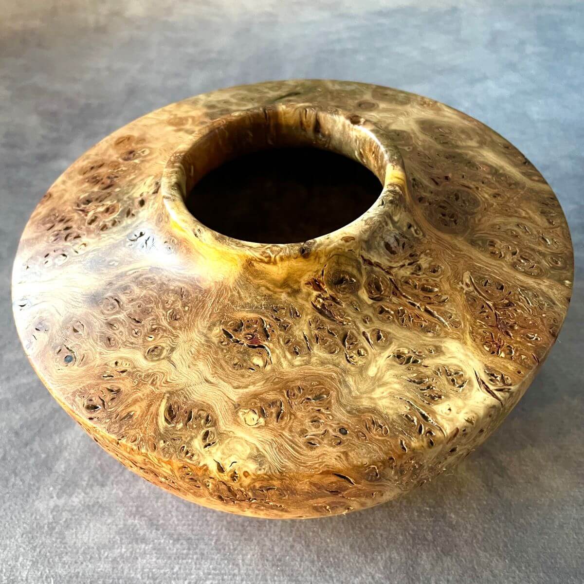 Wooden decorative vessel showing the hollowed centre opening and internal grain.