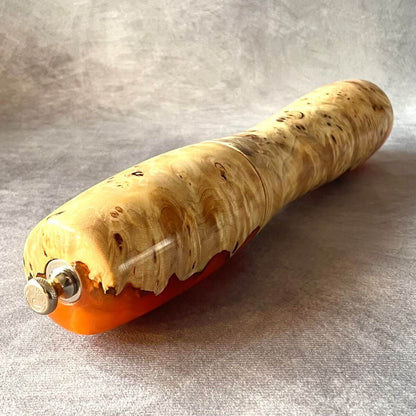 Side view of Mappa Burr and orange resin pepper mill showing turning curve and base.