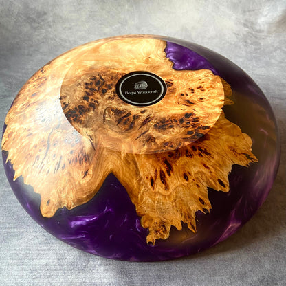 Base of handmade mappa burr and purple resin bowl – polished epoxy and burl wood art featuring Begat Woodcraft logo and intricate natural grain.
