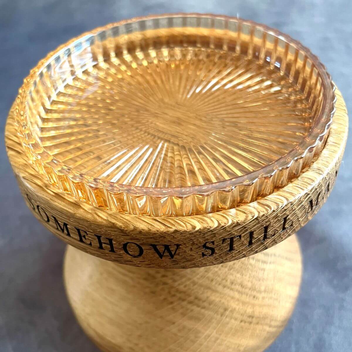 Close up detail of deep laser etching and glass insert on solid oak pillar candle holder, perfect for a 5th wedding anniversary gift.