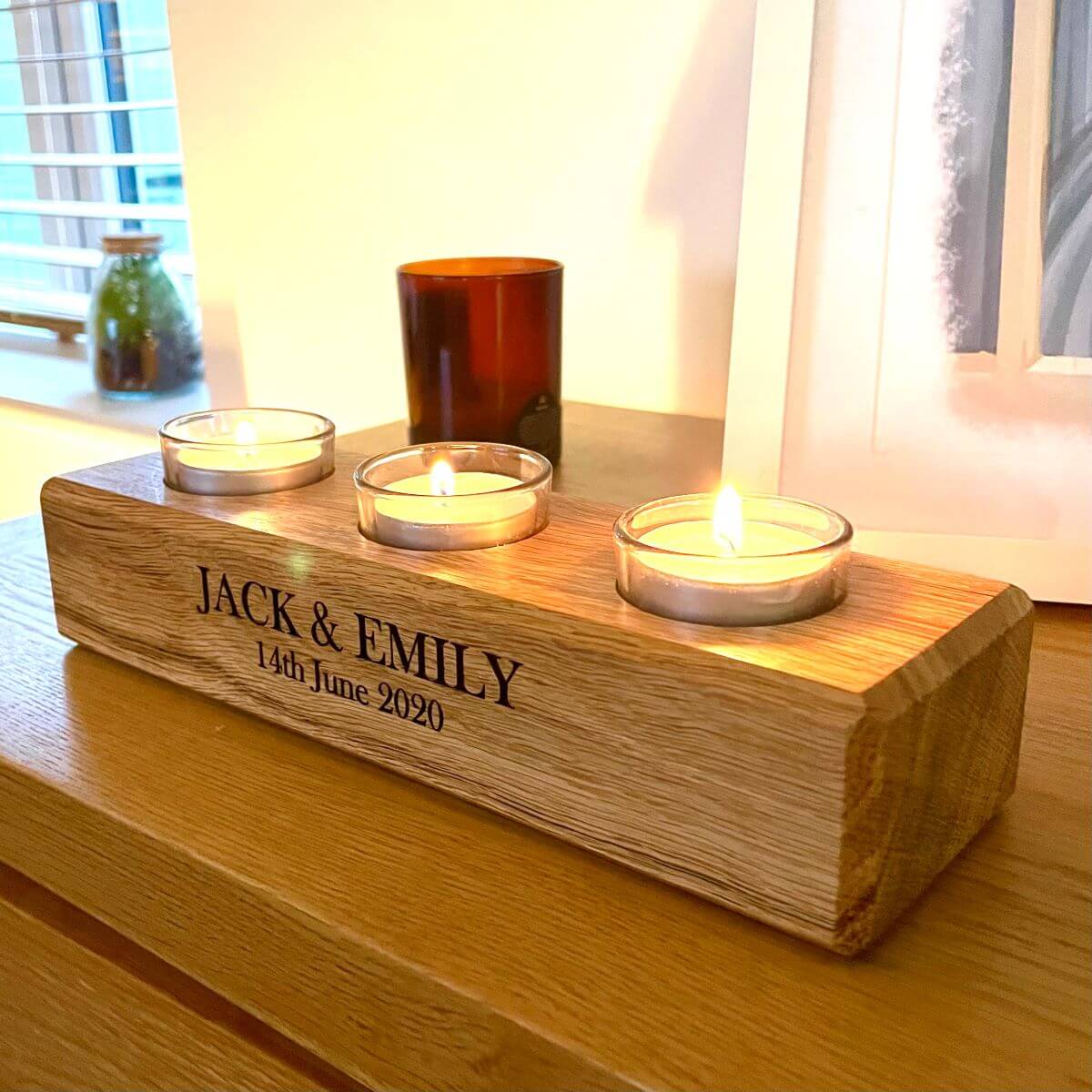 Personalised Oak Tealight Holder with 3 lit candles on dining table