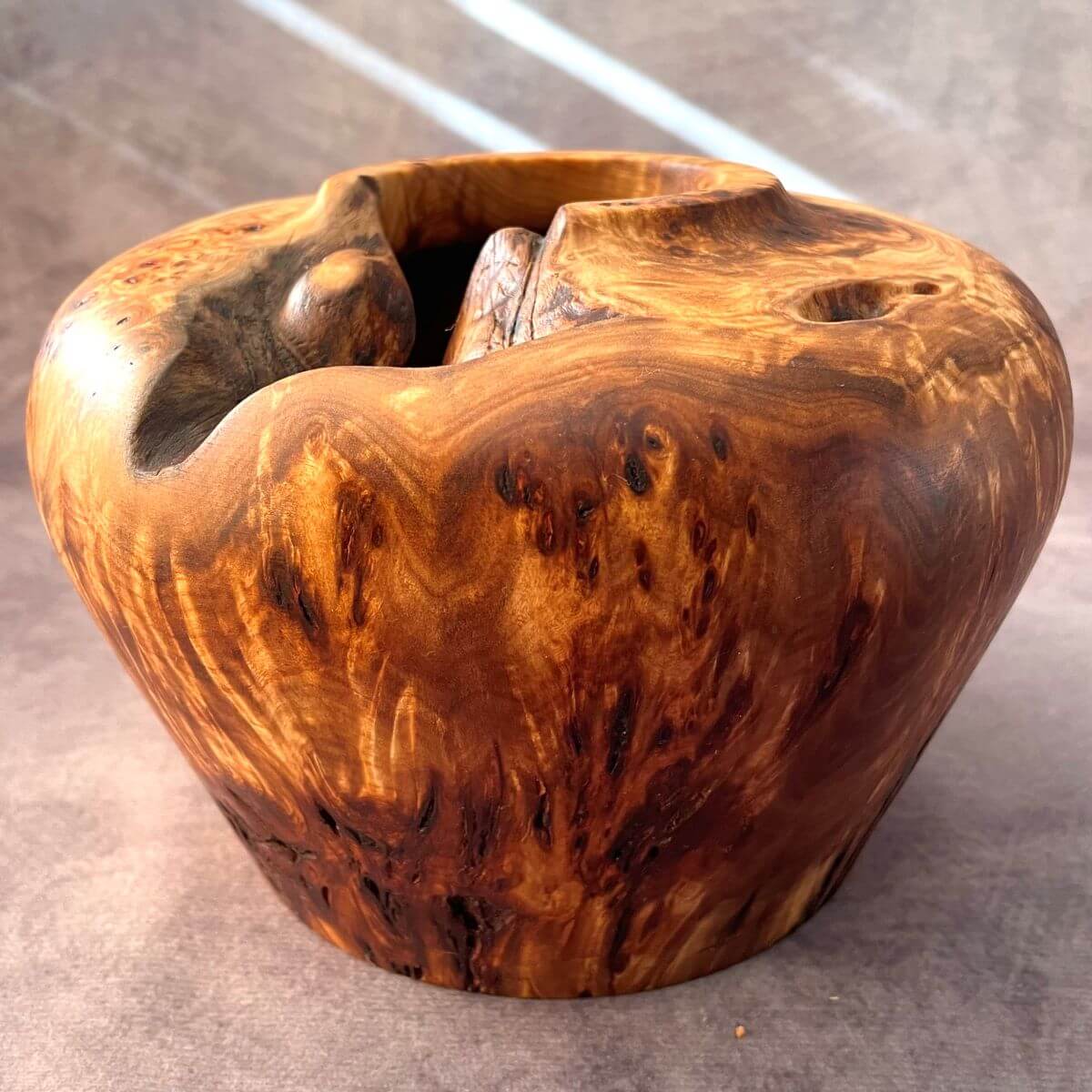 Front view of a Mappa burr turned wood vessel with natural live edges and voids.