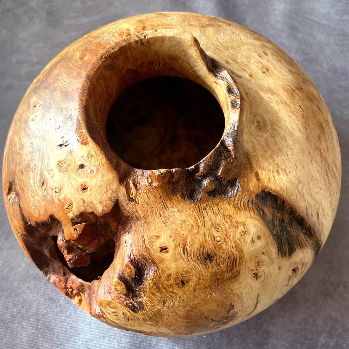 Top view of an English Oak burr turned wood vessel with natural edge voids showing opening