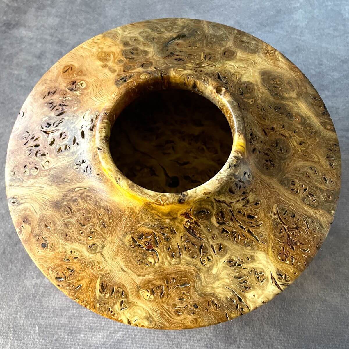 Top down view of wooden decorative vessel showing the hollowed centre opening and internal grain.