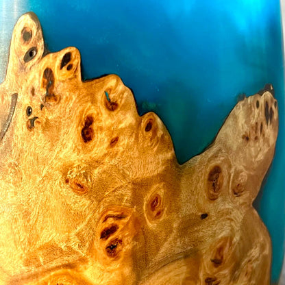 Close up detail of natural grain and jewel tone turquoise resin on a mappa burr decorative vase